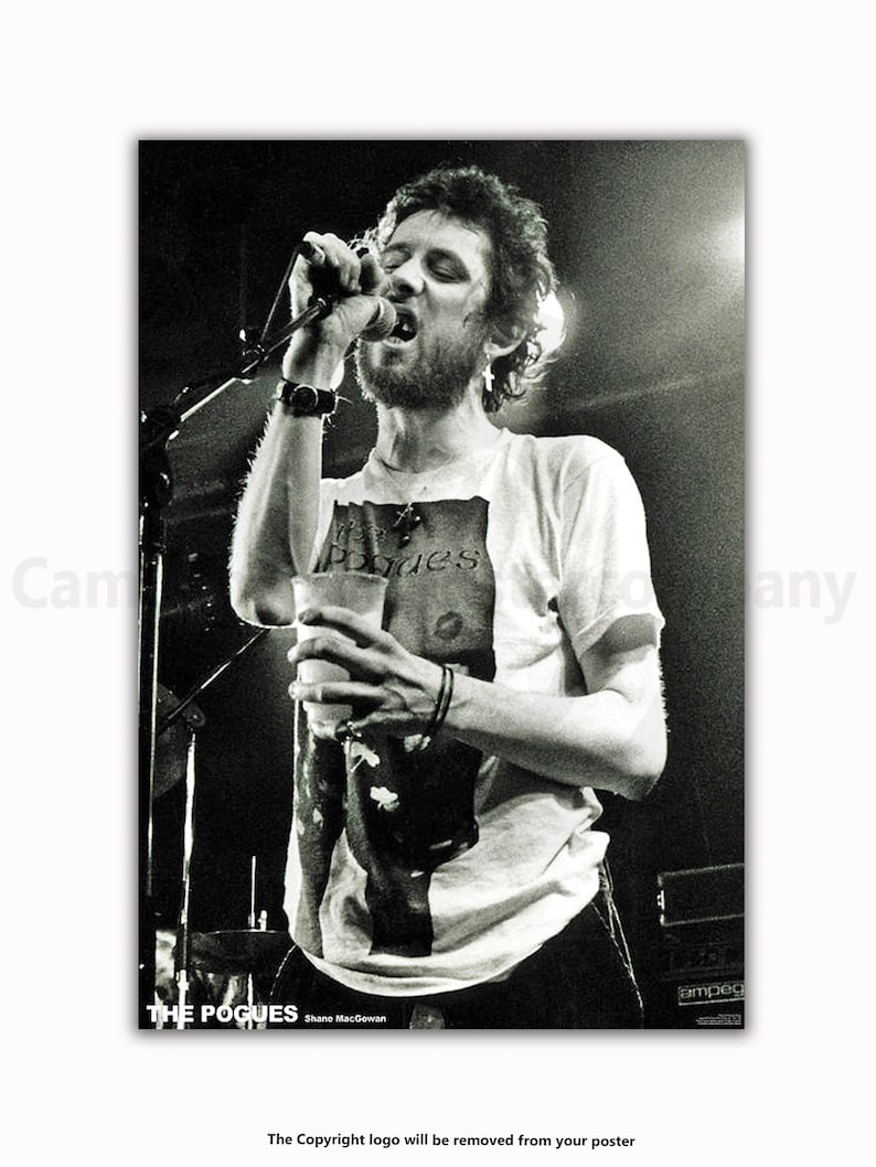 K&ouml;nnte beinhalten: Schwarz-wei&szlig; Konzertposter mit Shane MacGowan von The Pogues beim Singen in ein Mikrofon. Er tr&auml;gt ein wei&szlig;es T-Shirt mit Bandgrafik und h&auml;lt einen Becher. Der Bandname und Shanes Name sind unten aufgedruckt.