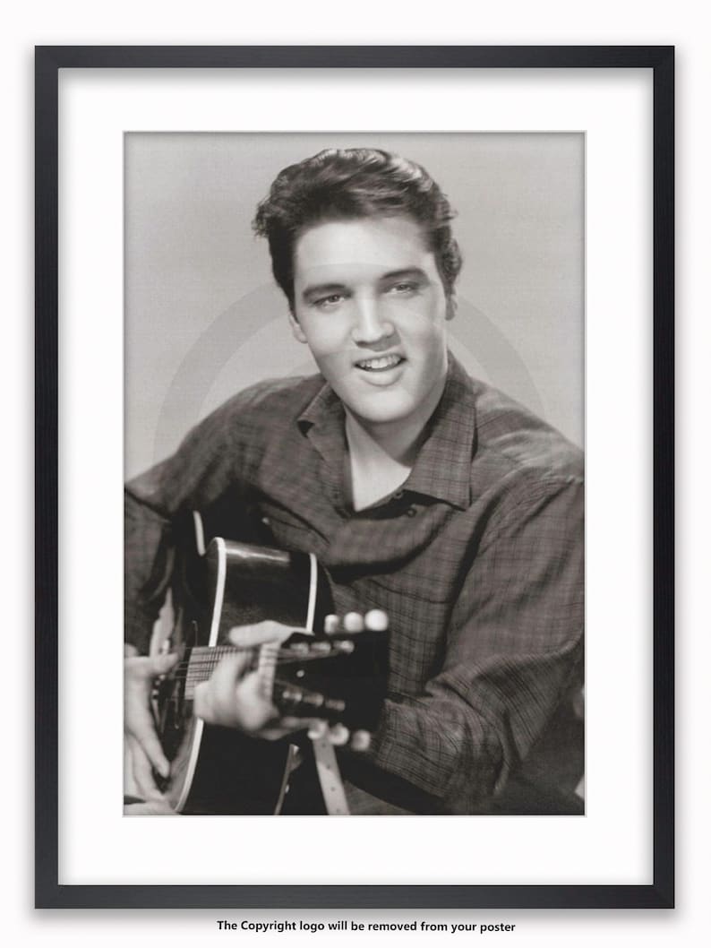 May include: Framed black and white print of a man playing a guitar. The man is smiling and wearing a plaid shirt. The print is in a black frame with a white mount.