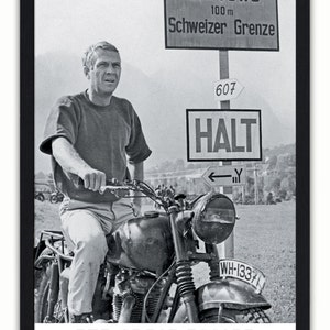 May include: Black and white framed poster featuring Steve McQueen on a motorcycle. The poster includes the text "ACHTUNG", "Schweizer Grenze", and "HALT". The title "THE GREAT ESCAPE" and the year "1963" are also visible.