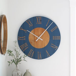 May include: A large, round, blue and wood clock with Roman numeral markings. The clock has a white hand and a wooden center.