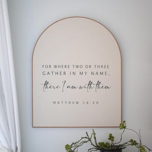May include: A beige arched wooden sign with the text "FOR WHERE TWO OR THREE GATHER IN MY NAME, there I am with them MATTHEW 18:20" in black lettering.