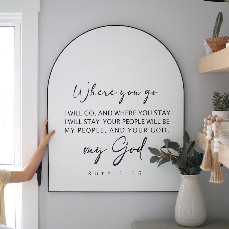 Puede incluir: Un letrero blanco en forma de arco con borde negro y el texto "Where you go I will go, and where you stay I will stay. Your people will be my people, and your God, my God. Ruth 1:16"