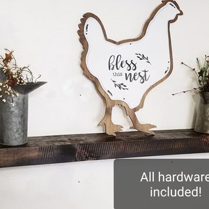 May include: A rustic wooden shelf with a chicken silhouette sign that says "bless this nest". The shelf is decorated with a lantern, a watering can, and two lanterns.