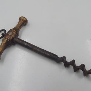 Abridor de botellas antiguo de bronce y acero, siglo XIX.