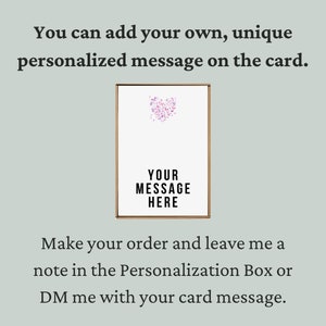 May include: A white card with a pink heart design and the text "YOUR MESSAGE HERE". The card is framed in a brown frame.