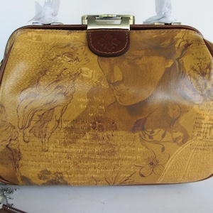 May include: A vintage-style handbag with a gold and brown color scheme. The bag features a detailed print of classical figures and floral elements. It has a brown leather trim, a clasp closure, and a top handle. The bag's design evokes a sense of classic art.