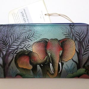 May include: A rectangular wallet with a colorful elephant design. The wallet features a painted scene of two elephants in a forest with trees and foliage. The color palette includes shades of blue, purple, red, and green.