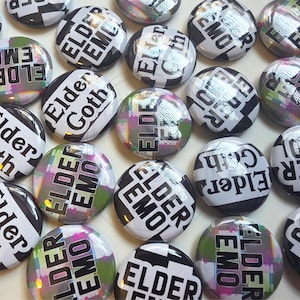 May include: A collection of round buttons with the phrases "Elder Emo" and "Elder Goth" in black and white. Some buttons have a colorful, pixelated design. The buttons are arranged closely together.