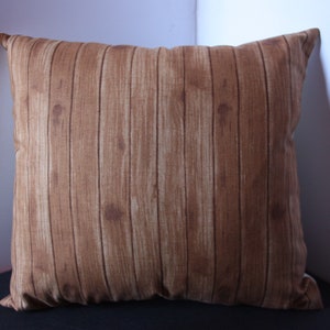 May include: A brown throw pillow with a wood plank pattern.