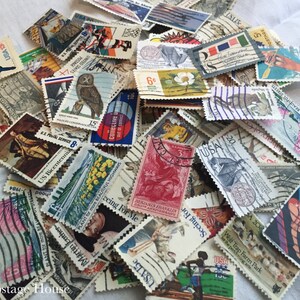 May include: A collection of vintage US postage stamps featuring a variety of designs, including owls, flowers, and historical figures. The stamps are in various colors and sizes, and some have been used.