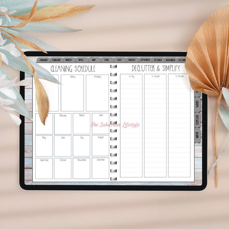 Puede incluir: Un planificador digital con un fondo de madera azul y blanco. El lado izquierdo del planificador es un calendario de limpieza mensual con los meses del a&ntilde;o listados. El lado derecho del planificador es una secci&oacute;n de limpieza y simplificaci&oacute;n con columnas para "Comprar", "Donar" y "Descartar".
