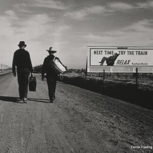 May include: Two people walk down a dirt road with suitcases. A billboard in the distance reads "Next time - try the train - Relax - Southern Pacific".