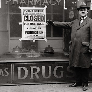 May include: A black and white photo of a storefront with a sign that reads 