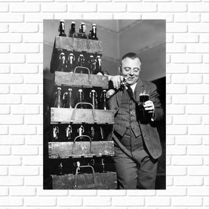 May include: A black and white photo of a man opening a bottle of beer. The man is wearing a suit and tie. He is standing in front of a stack of wooden crates filled with bottles of beer. The crates are labeled 