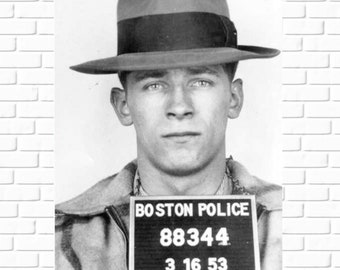 May include: Black and white mugshot of a man wearing a fedora hat. The man is facing the camera and holding a sign that reads "BOSTON POLICE 88344 3 16 53". The image is a vintage photograph.