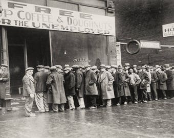 May include: A black and white photo of a line of people waiting outside a building. A sign above the entrance reads "Free Coffee & Doughnuts for the Unemployed".