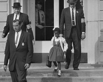 May include: A young girl in a red dress and white cardigan walks down steps with two men in suits. The men are wearing badges and one has a white armband with the text "Deputy Marshal" on it.