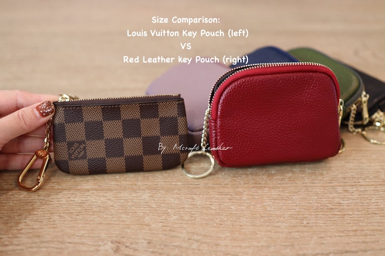 Puede incluir: Comparaci&oacute;n de tama&ntilde;o de dos llaveros. Un llavero a cuadros marr&oacute;n y beige con una cadena dorada y un llavero de cuero rojo con una cadena dorada. El texto "Comparaci&oacute;n de tama&ntilde;o: Llavero Louis Vuitton (izquierda) VS Llavero de cuero rojo (derecha)" est&aacute; por encima de los llaveros.