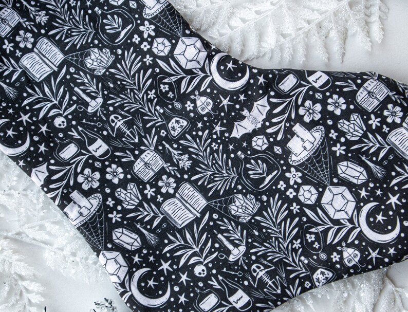 May include: Black and white stocking with a repeating pattern of crystals, moons, bats, and other witchy imagery.