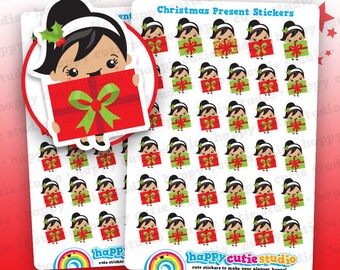 Puede incluir: Hojas de pegatinas de regalos de Navidad. Las pegatinas presentan una niña de dibujos animados sosteniendo un regalo rojo con un lazo verde, e imágenes de la niña con cajas de regalo verdes y rojas. El texto incluye "Christmas Present Stickers" y "happy cutie studio".