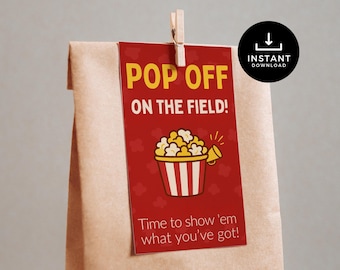 May include: A red tag with the words "POP OFF ON THE FIELD!" and a popcorn graphic is clipped to a brown paper bag. The tag also includes the text "Time to show 'em what you've got!" and an "INSTANT DOWNLOAD" icon.