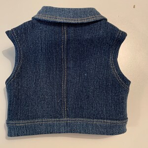 May include: A blue denim vest with a collared neckline and sleeveless design.