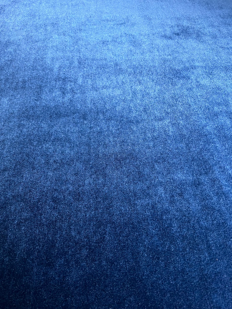 May include: A close-up of a dark blue fabric with a textured surface.