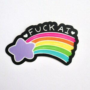 A sticker of a purple shooting star with a rainbow tail that has the works "F-ck AI" above it with two hearts on either side of the text.