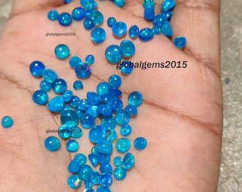May include: A collection of blue opal cabochons, a type of gemstone, in various sizes. The opals are iridescent and have a light blue color.