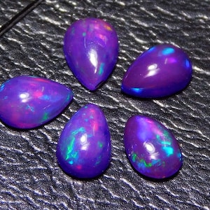 May include: Five pear-shaped purple opals with iridescent flashes of colour.