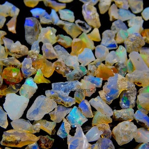 May include: A collection of rough, natural opal gemstones in various sizes and shapes. The opals are a mix of white, clear, and iridescent colours.