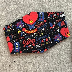 May include: Two black fabric face masks with a red heart design and colorful text including "BT Planet", "Super Natural", "Cool", "Super Curious", "TATA", and "BT21".