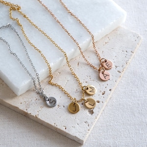 Custom family initials necklace with multiple engraved letter charms on one chain.