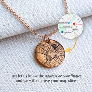Puede incluir: Un collar de oro rosa con un colgante circular grabado con un diseño de mapa. La cadena y el colgante son visibles sobre un fondo claro. La imagen incluye un mapa de Canterbury, Inglaterra, y el texto: "Just let us know the address or coordinates and we will engrave your map slice."