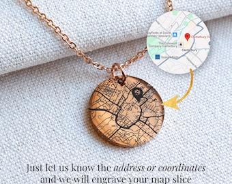 May include: A rose gold necklace with a circular pendant engraved with a map design. The chain and pendant are visible against a light background. The image includes a map of Canterbury, England, and the text: "Just let us know the address or coordinates and we will engrave your map slice."