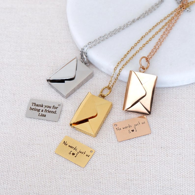 Envelope locket necklace in sterling silver, shown open with a tiny engraved secret message note visible.