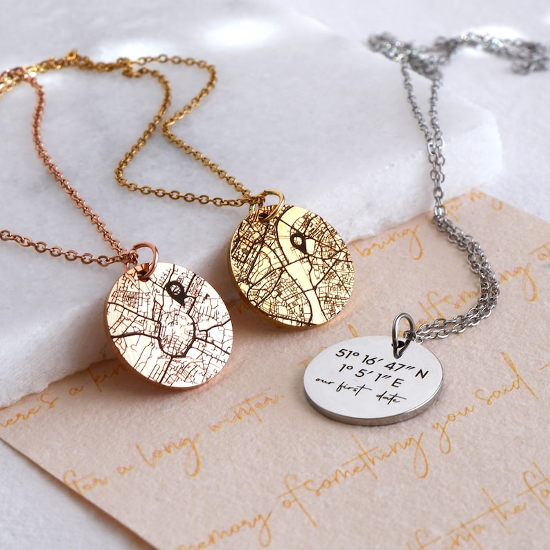 Personalised map and coordinates necklaces displayed with engraved pendant designs