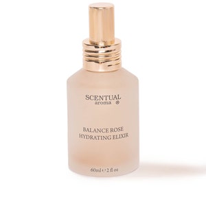 Puede incluir: Una botella de vidrio esmerilado con una tapa y una etiqueta doradas. La etiqueta dice "Scentual aroma® Balance Rose Hydrating Elixir 60ml e 2 fl oz".