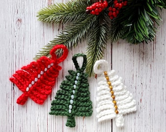 May include: Three handmade Christmas tree ornaments, one red, one green, and one white, with white, green, and gold beads, respectively. The ornaments are hanging from a branch of a green artificial Christmas tree.