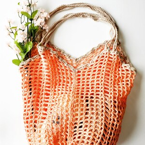May include: A crocheted orange and beige mesh bag with a wide, open top and two handles. The bag is made of a delicate, open weave and has a slightly textured surface.