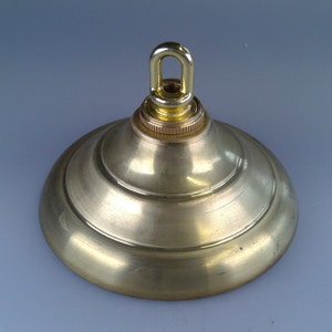 May include: A brass ceiling canopy with a ring for hanging a light fixture.