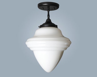 May include: A black ceiling light fixture with a white glass shade. The shade is shaped like a cone with a wide base and a narrow top. The light fixture has a simple design and would be a great addition to any home.