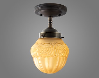 May include: A ceiling light fixture with a bronze finish and a frosted glass shade with a rose pattern.