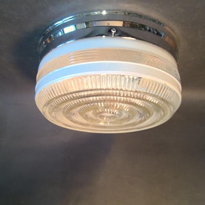 May include: A chrome and white ceiling light fixture with a clear glass shade featuring a ribbed design.