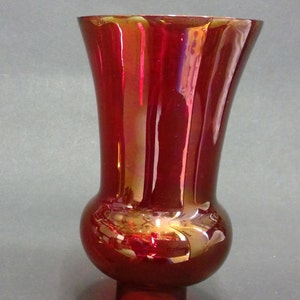 以下が含まれることがあります： 丸いベースと広がったトップを持つ赤いガラス製のハリケーンランプシェードです。