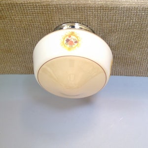 May include: A vintage ceiling light fitting with a white and cream glass shade. The fitting features a decorative floral design and a chrome metal base. The light is designed for ceiling mounting.