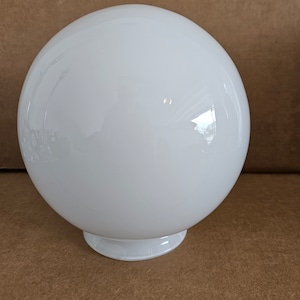 May include: A white glass globe light fixture with a round base.