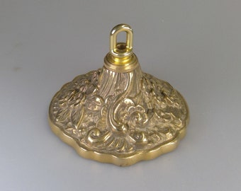 May include: Gold-toned metal ceiling fixture with an ornate design and a hanging loop.
