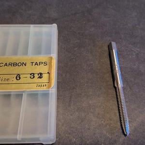 May include: A clear plastic case with a gold label that reads "Yorkville Metal Electrics Carbon Taps Size: 6-32 Japan". A silver tap is shown next to the case.