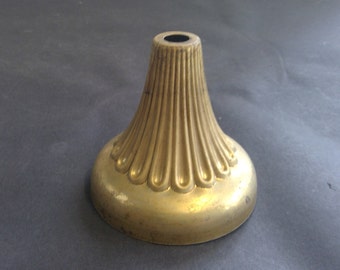 May include: A gold metal lamp base with a fluted design and a round top.